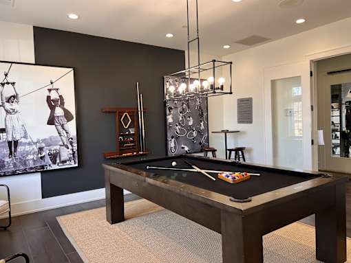 a billiards table in a game room with a painting on the wall