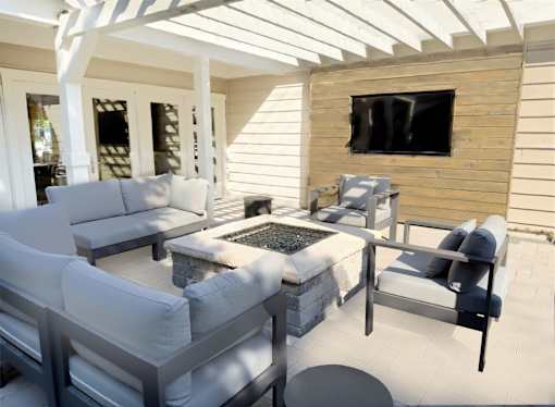 A patio with white furniture and a flat screen TV mounted on a wooden wall.