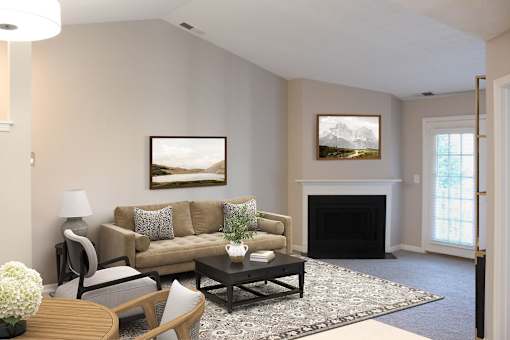 A living room with a fireplace and a painting on the wall.