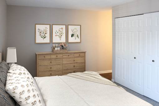 A bedroom with a bed, dresser, and three framed pictures on the wall.