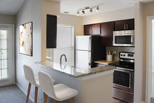 A kitchen with a white chair and a white counter top.