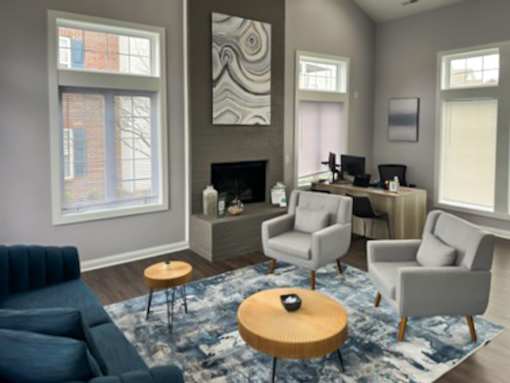 a living room with a blue couch and chairs and a rug