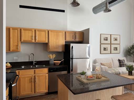 A modern kitchen with wooden cabinets and black appliances.