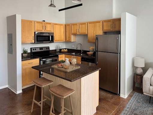 A kitchen with wooden cabinets and a black refrigerator.