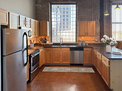 A kitchen with wooden cabinets and a large window.