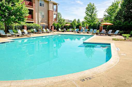 Sparkling outdoor pool surrounded by pristine landscaping