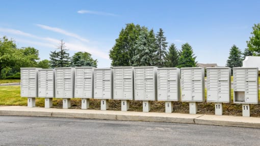 a row of white mailboxes on the side of a street
