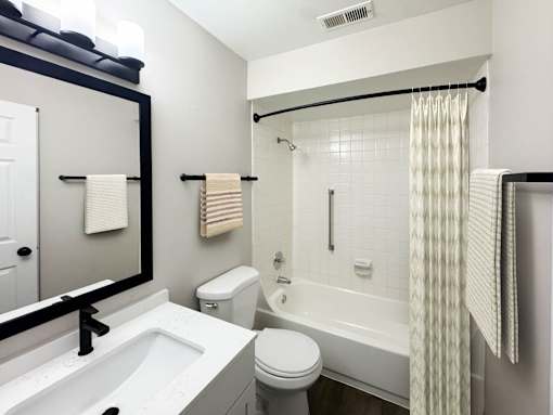 A white bathroom with a toilet, sink, and bathtub.