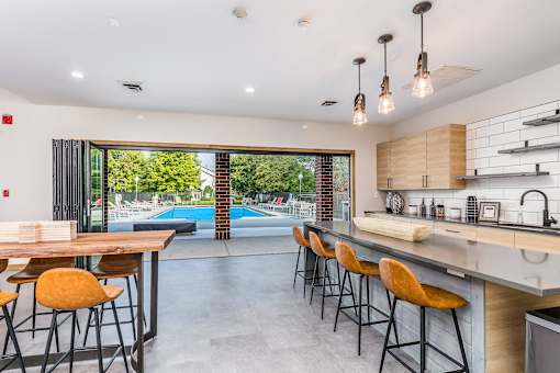 A modern kitchen with a pool outside the window.
