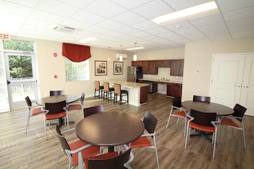 A dining room with a table surrounded by chairs.