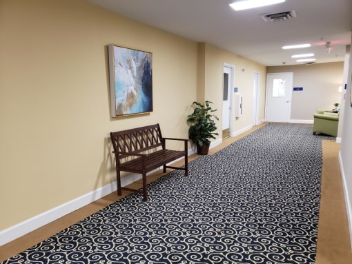 a bench in a corridor with a painting on the wall
