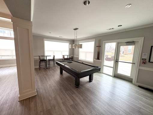 A spacious room with a pool table and a view of the outside.