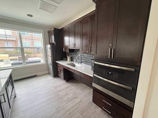 A kitchen with dark wood cabinets and a black oven.