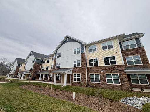 A large, multi-story residential building with a mix of brick and siding exteriors.