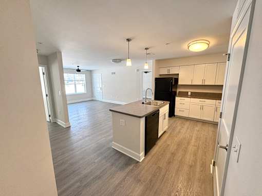 A kitchen with a black fridge and white cabinets.