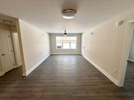 A room with a window and a light fixture on the ceiling.