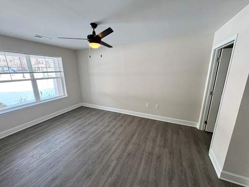 A room with a ceiling fan and a window.