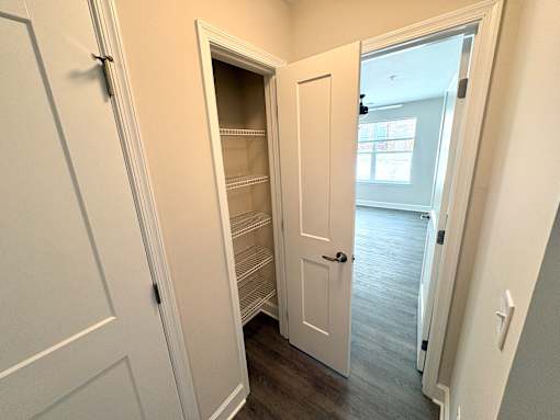 A white door is open to a room with a window.