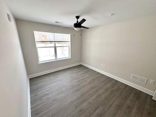 A room with a ceiling fan and a window.