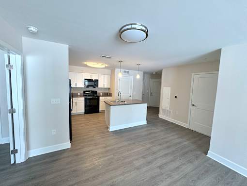 A kitchen with white cabinets and a black dishwasher.