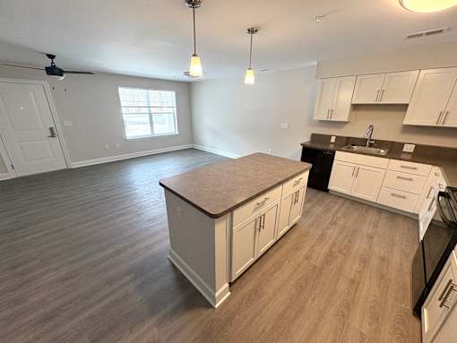 A kitchen with white cabinets and a wooden island.