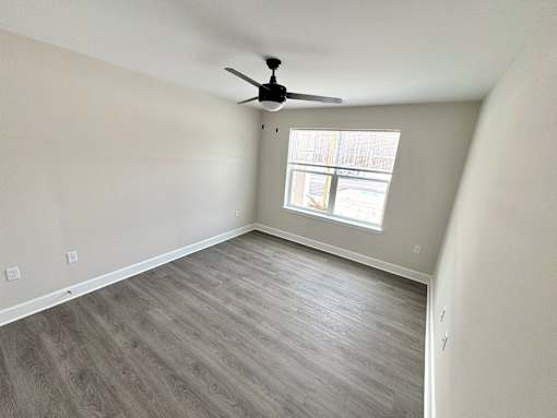 A room with a ceiling fan and a window.