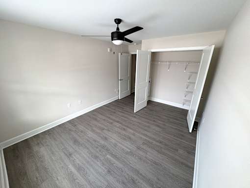 A room with a ceiling fan and a walk-in closet.