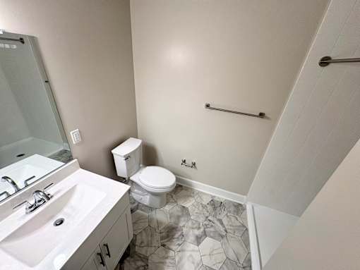 A bathroom with a toilet, sink, and a shower.