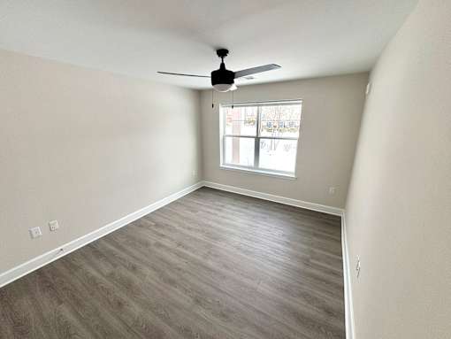 A room with a ceiling fan and a window.