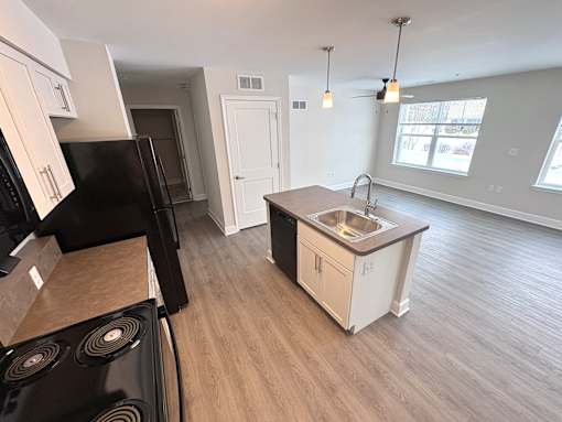 A kitchen with a black stove top oven and a black refrigerator.