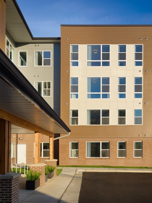 an exterior view of an apartment building with a sidewalk