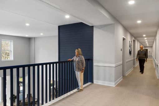 a hallway with white walls and a blue wall with mannequins in it