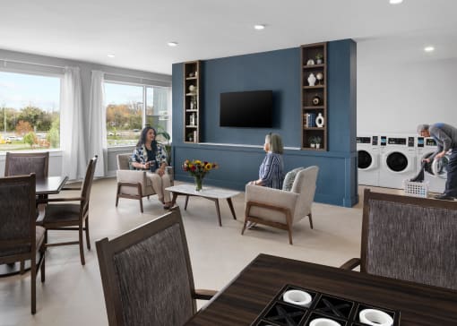 two people sitting in a living room with a dining room and a laundry room