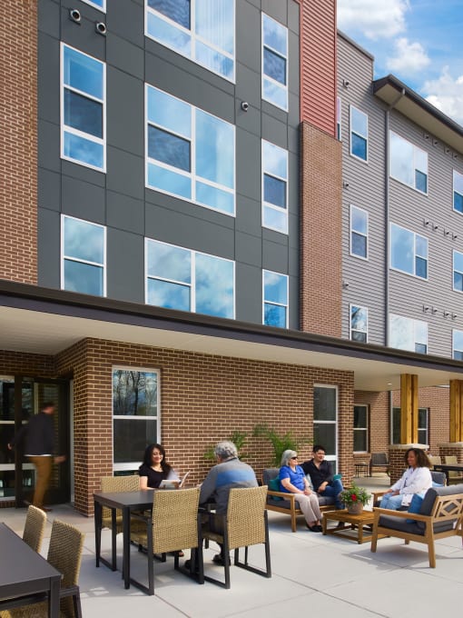 a group of people sitting at a table outside of a building