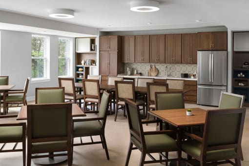 a large dining room with tables and chairs and a kitchen