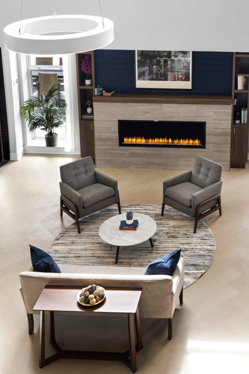 a living room with chairs and a fireplace