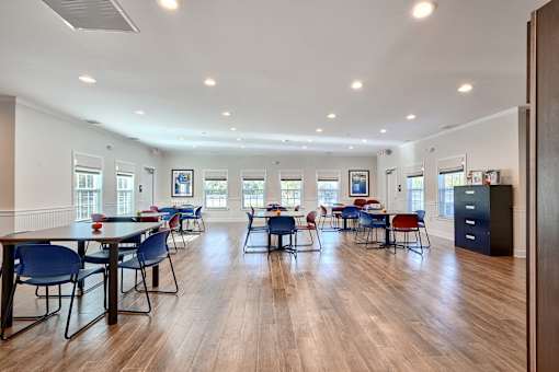 a dining room with blue chairs and tables and a wood floor