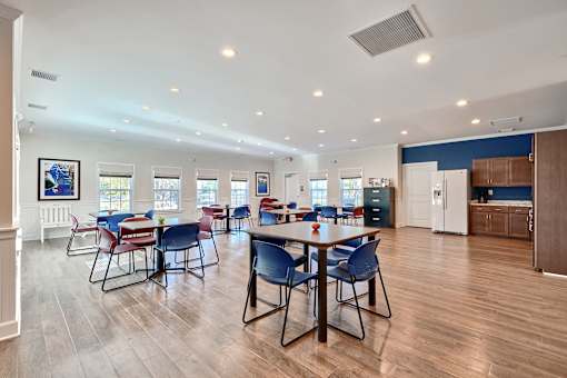 a dining room with tables and chairs and a kitchen