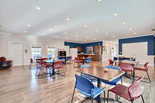 a dining room with tables and chairs and a kitchen