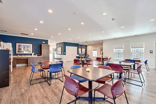 a dining room with tables and chairs and a kitchen