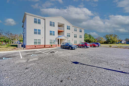 a parking lot with cars in front of an apartment building