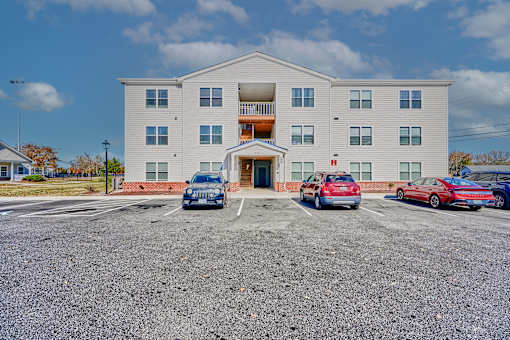 a large white building with cars parked in front of it