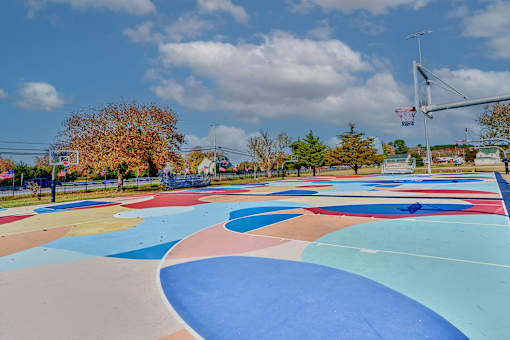a basketball court in a park with a blue sky