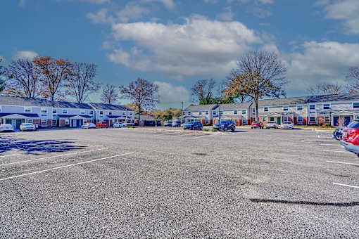 a parking lot filled with cars in front of buildings
