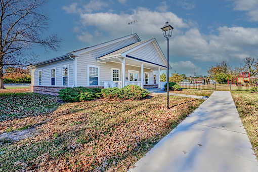 a white house with a sidewalk and a street light