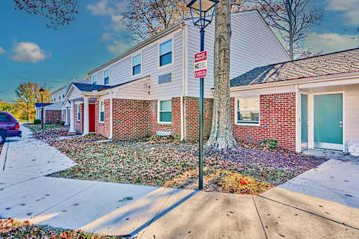 a red brick house with a street sign on the sidewalk