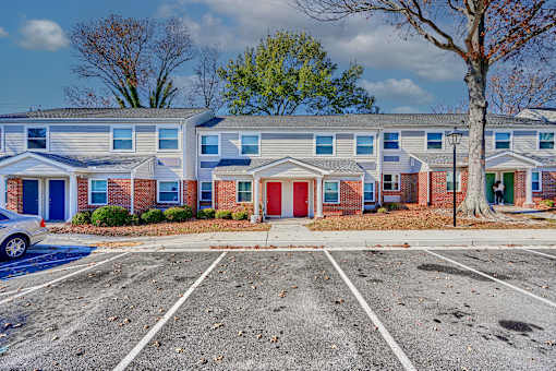 an empty parking lot in front of a building with a red door