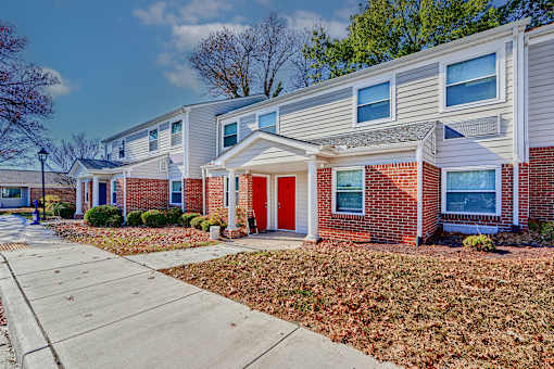 a red door on a brick house with a sidewalk