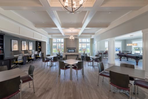 a large room with tables and chairs and a pool table in the background