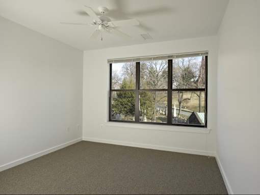 A room with a window and a ceiling fan.